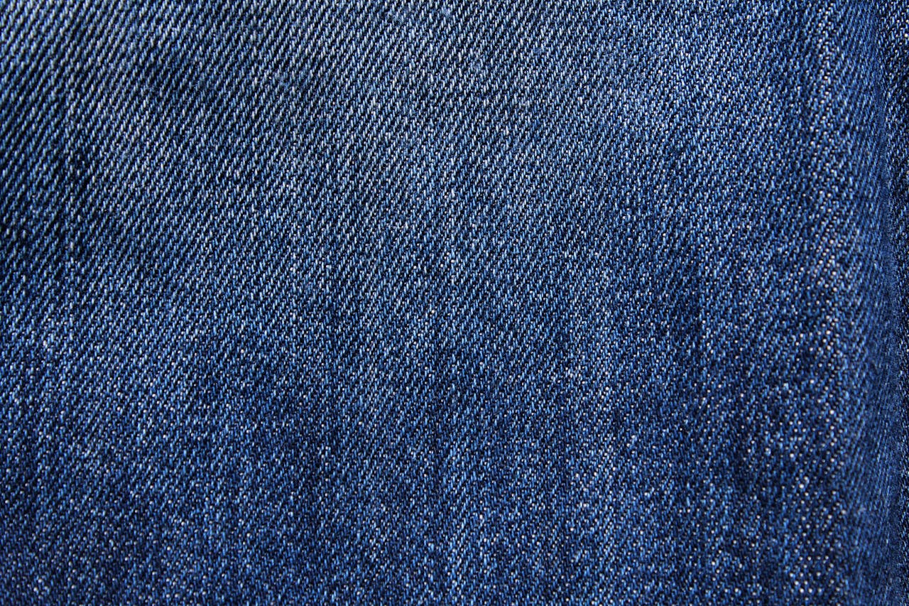 Textured blue denim fabric with detailed weaving visible in close-up macro view.